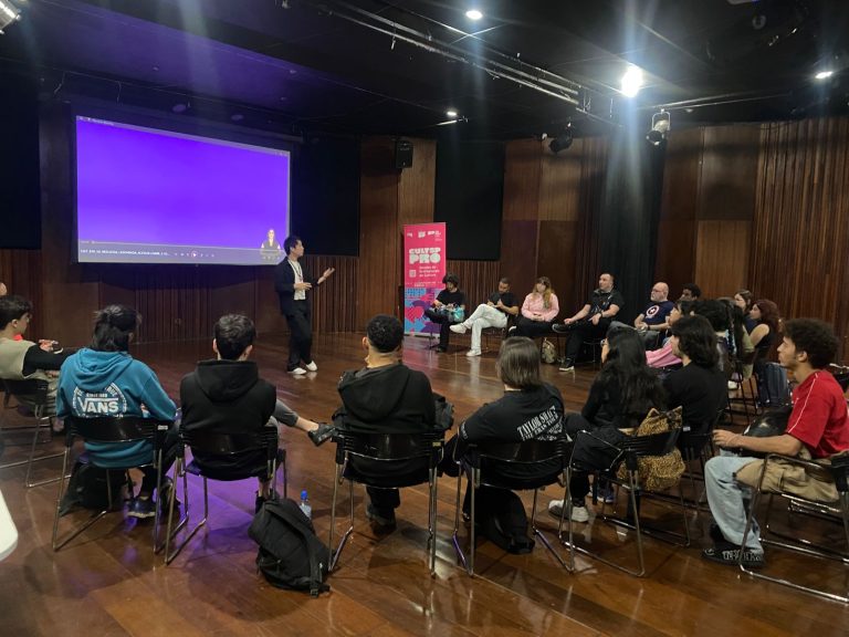 Foto de grupo de alunos sentados assistinto uma pessoa falar no auditório 7 no Oswald de Andrade.