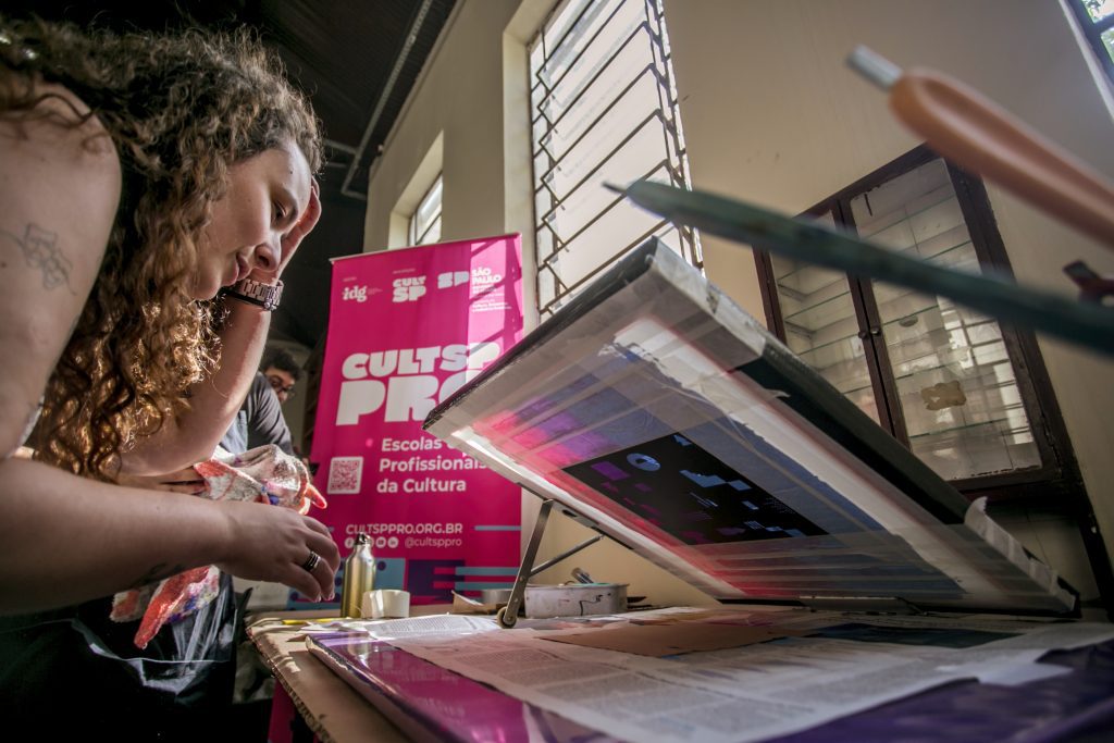 Foto de mulher fazendo estampa em embalagem em ateliê do Complexo Cultural Oswald de Andrade.