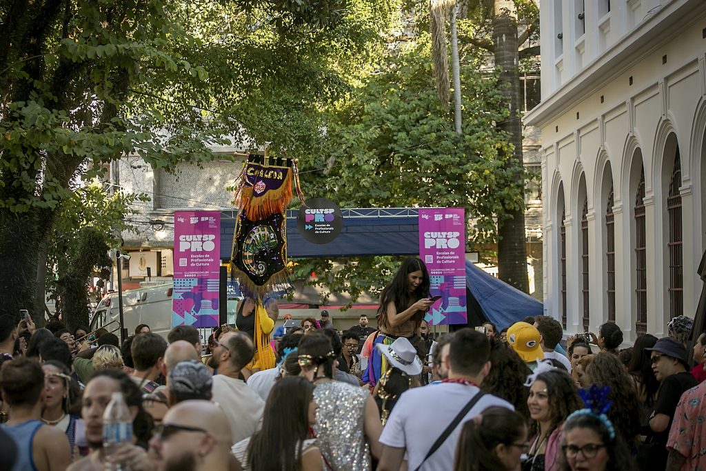 Foto de pessoas dançando na frente do Complexo Cultural Oswald de Andrade com bloco de carnaval.