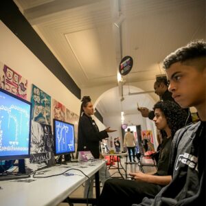 Foto de jovem na frente de tela de computador na galera do Complexo Cultural Oswald de Andrade.