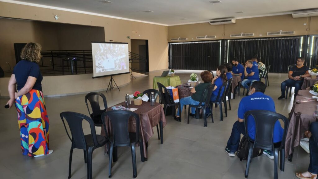 Foto de grupo de pessoas assistindo palestra em salão na cidade de Mira Estrela.