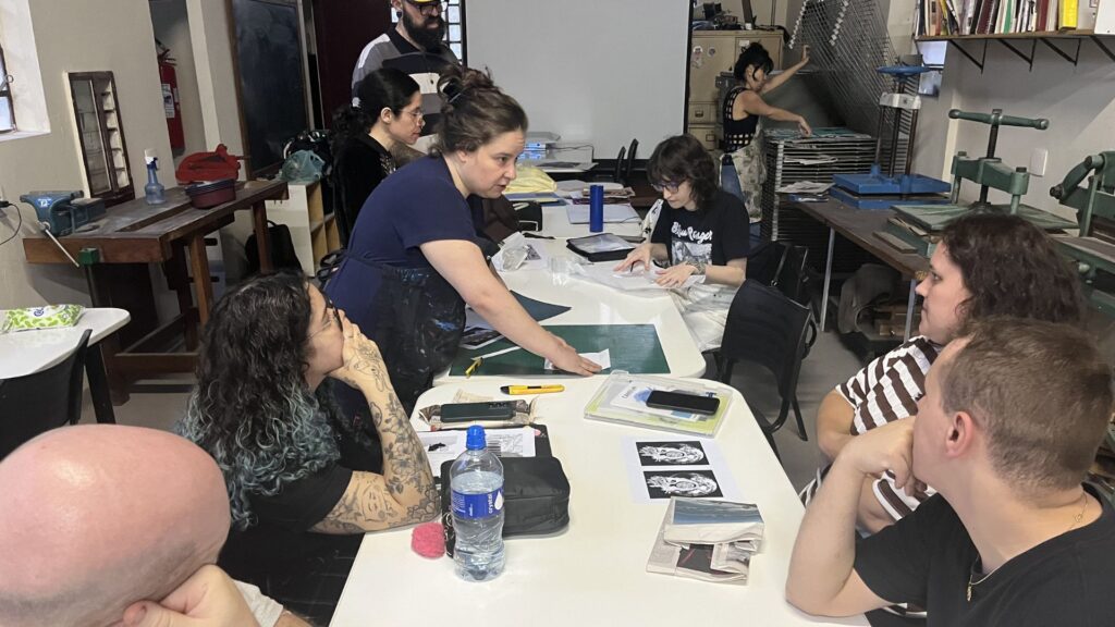 Foto de professora ensinando estampa e ilustração no ateliê de gravura do Oswald.