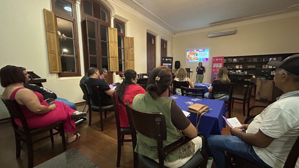 Foto de grupo de pessoas assistindo palestra em prédio histórico em Agustos (SP).