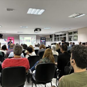 Foto de palestrante falando com auditório lotado em Mogi das Cruzes (SP).